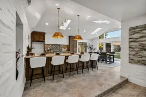 Modern open-concept kitchen with large island and vaulted ceilings photographed for a Sacramento real estate listing.