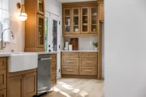 Bright custom bathroom with white farmhouse sink, natural wood cabinetry, and built-in storage photographed for a Sacramento real estate listing.